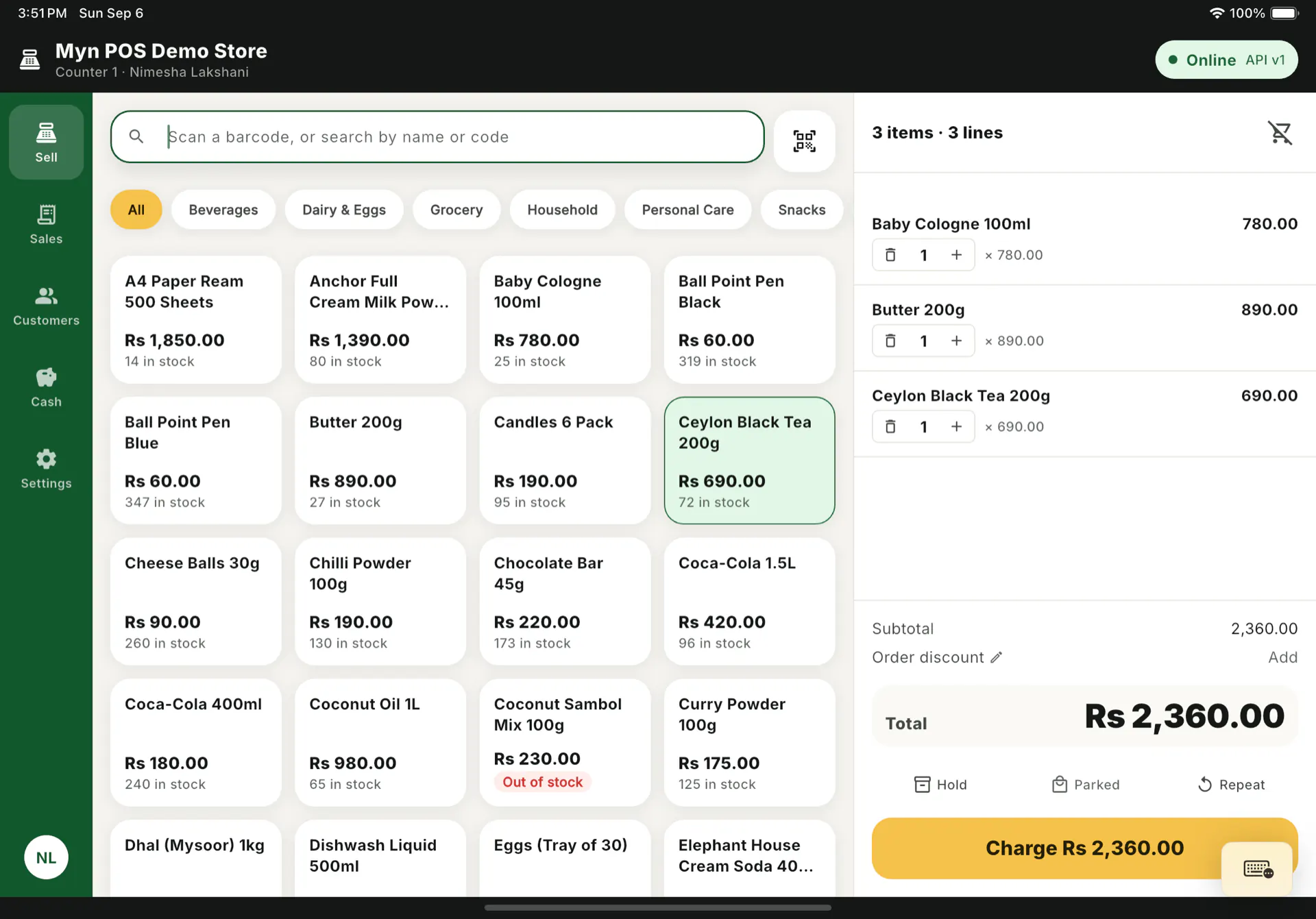 The Myn POS Sell screen on an iPad: a product catalog with prices and stock on the left, a three-line sale totalling Rs 2,360.00 on the right, and a Charge button.